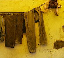 C-156 2011 - Jeans and a sweater drying under a yellow awning by Marjolein Katsma