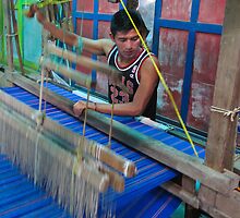 young man working a hand loom- El Salvador by David Chesluk