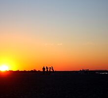 family on sandy hook beach during sunset by bhavindalal